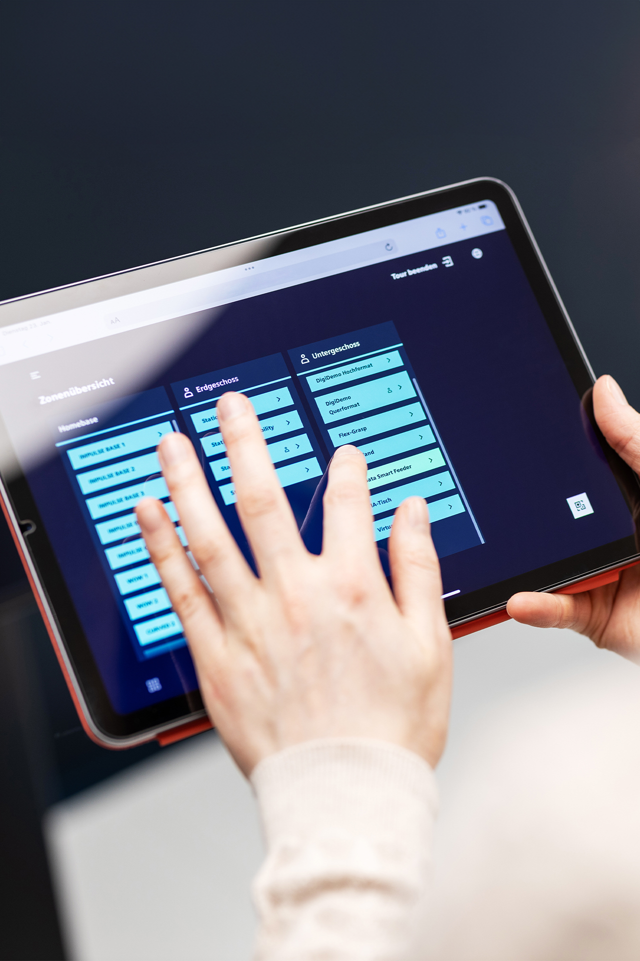 Jemand bedient Guide Tablet, um die Inhalte des Showrooms auf den Kunden anzupassen – personalisierte Kundenansprache