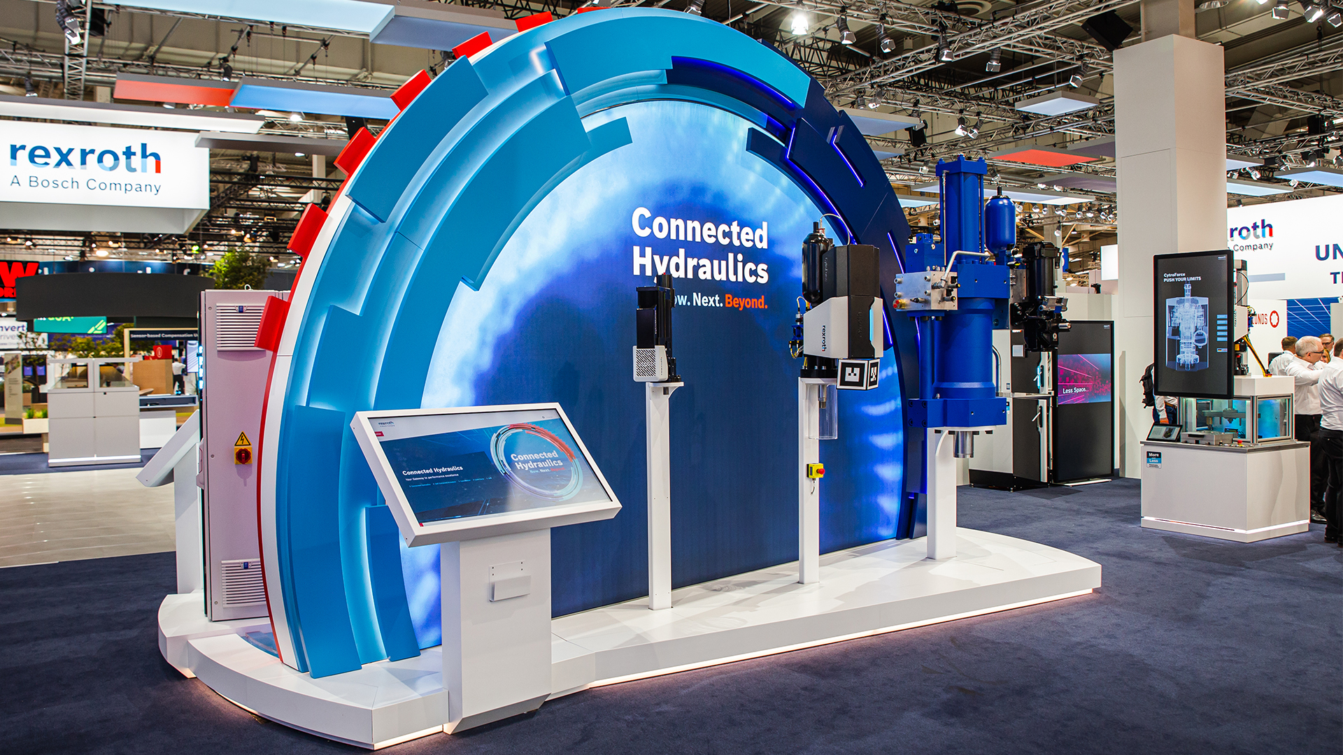 Blaues, halbkreisförmiges Exponat mit Maschinenteilen und digitalen 3D-Inhalten auf Messe – Vertriebsprozesse optimieren