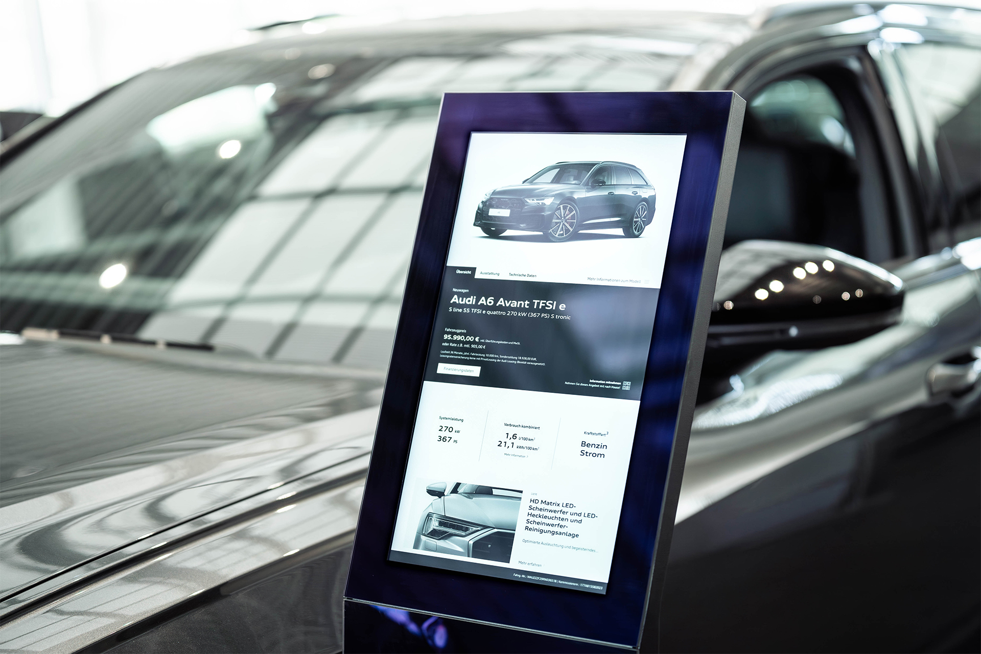 Ein B12-Touch Produktbeisteller vor einem schwarzen Auto – interaktive Vertriebspräsentation von Verkaufsfahrzeugen