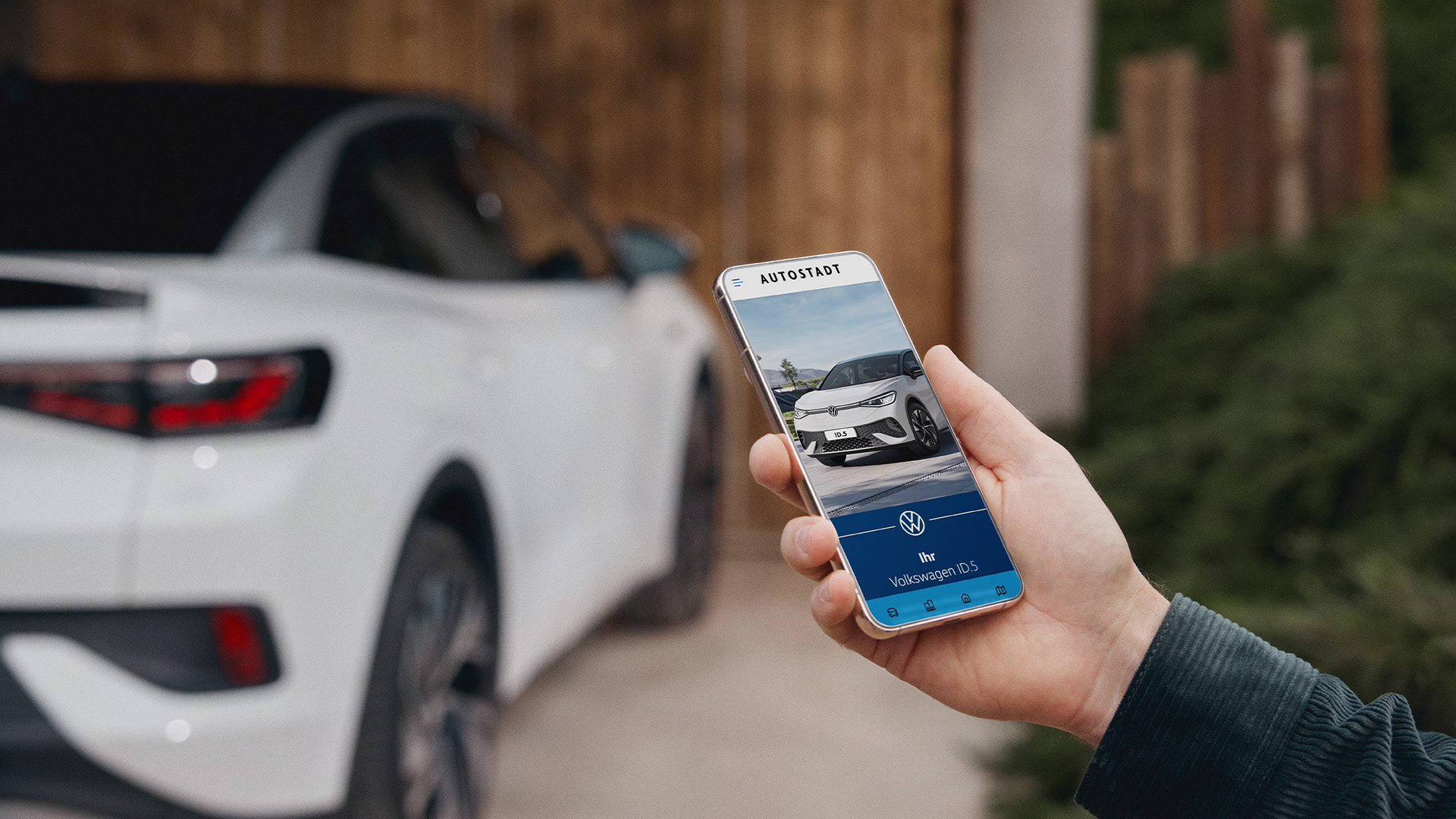 Hand hält ein Smartphone mit geöffneter VW Abholer Web-App vor einem weißen Auto – B12 Headless CMS Vertrieb
