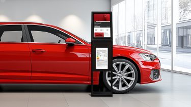 The product display developed by B12-Touch stands in front of a red car in a car dealership - Digital Info Display (DID)